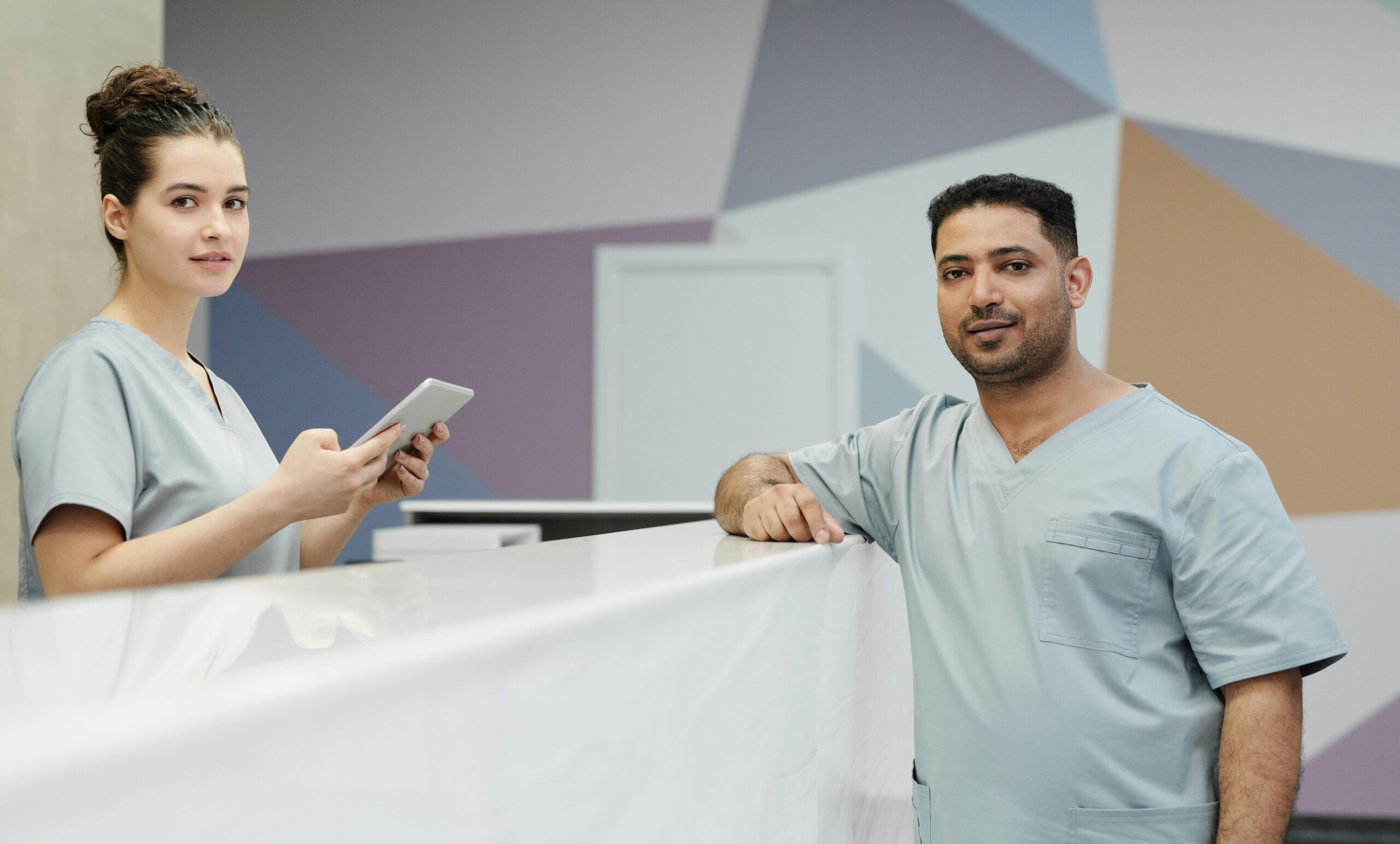 Medical staff members in scrub suits at a modern clinic's reception area.